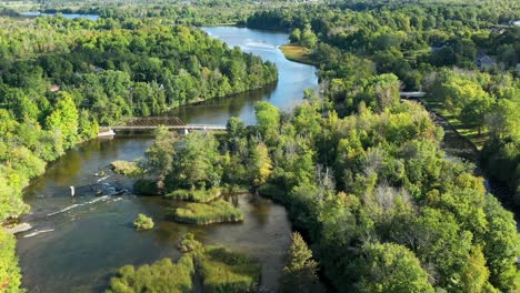 Winding-rideau-river-in-the-summer-near-Ottawa-with-an-old-metal-bridge-and-green-trees