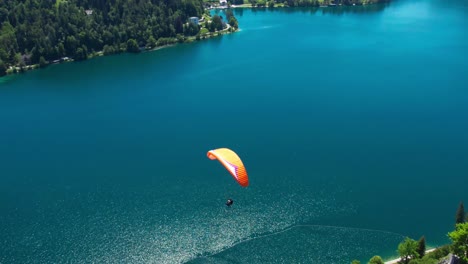Incredible-aerial-view-of-paraglider-in-Lake-bled-Slovenia,-amazing-scenery,-day