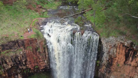 Rising-up-and-panning-down-view-of-water-flowing-over-the-Trentham-Falls-after-rain-on-22-Sepember,-2021,-Victoria,-Australia