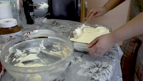 Homemade-Whipped-Cream-Being-Smoothed-Out-Across-Ladyfingers-By-Spatula