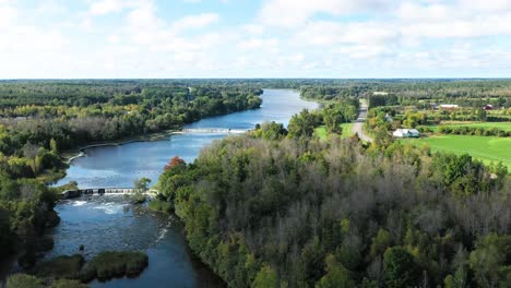 Rideau-river-near-Ottawa-in-summer-with-blue-skies-white-clouds-green-trees-and-water-falls