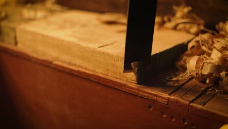 Closeup-of-a-carpenter-cutting-a-woooden-plank-with-a-japanese-saw,-professional-carpenter-working-at-hhis-workshop