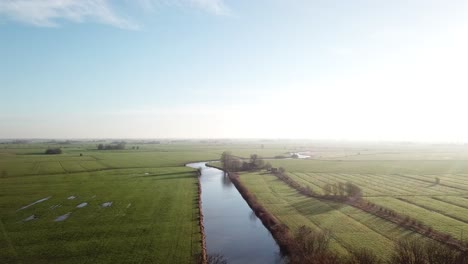 Drone-shot-of-big-landscape-and-a-canal-flowing-in-the-middle