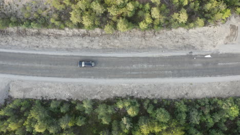 4k-Luftbild-Von-Oben-Auf-Sommergrüne-Bäume-Im-Wald-Und-Ein-Auto,-Das-Auf-Der-Waldlandstraße-Fährt