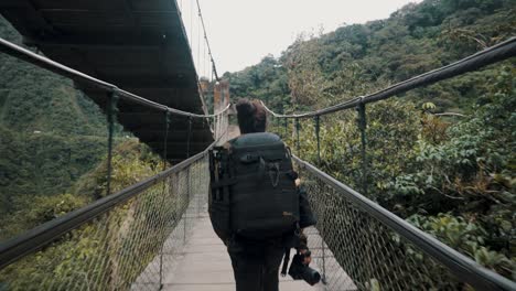 Backpacker-überqueren-Auf-Einer-Hängebrücke-über-Den-Wasserfall-Pailon-Del-Diablo-In-Baños,-Ecuador