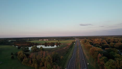 A-drone-shot-of-majestic-sunset-in-the-wonderful-landscape-with-dramatic-sky-background-and-an-asphalt-road-is-seen