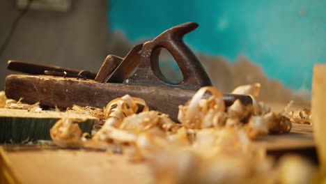 Wood-planer-lying-in-a-carpenter-workshop-with-wood-waste,-closeup-of-carpenting-tools,-process-of-making-wood-furniture,-professional-carpenting-tools