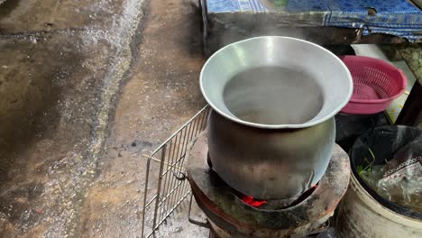 Aus-Einem-Topf-Auf-Dem-Thailändischen-Holzkohlekocher-Entweicht-Heißer-Kochender-Dampf