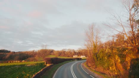 Countryside-road-in-UK-Glastonbury-at-golden-hour-with-farm-and-fields