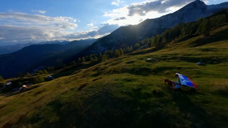 Fpv-footage-was-filmed-in-the-Slovenian-mountain-village-in-the-alps-with-a-drone-flying-fast-over-mountains-filmed-with-a-GoPro-with-incredible-surrounding-landscapes-with-a-hiker-holding-a-flag-2