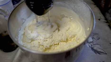 Cream-Being-Whisked-By-Machine-On-Kitchen-Table