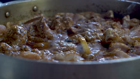 Close-Up-View-Of-Simmering-Chicken-Curry-With-Lemon-Slice-In-Large-Pot