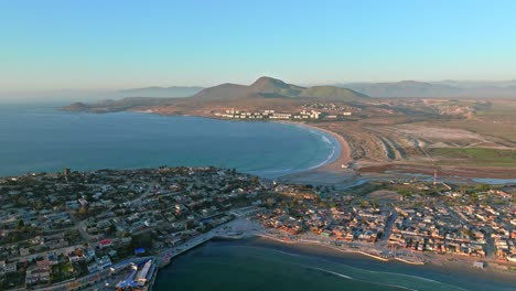 Dolly-in-aerial-view-of-the-Tongoy-peninsula-with-Socos-beach-and-the-arid-mountains-of-northern-Chile-on-the-horizon