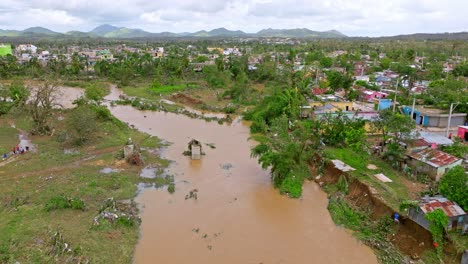 Aerial-flyover-overflooded-Yuma-river-in-poor-district-of-los-platanitos-on-Domitian-republic-island---environmental-catastrophe-on-earth