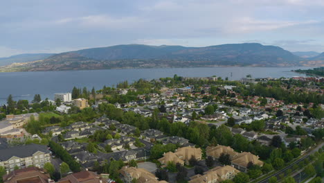 Aerial-angle-backing-away-to-reveal-homes,-mountains,-and-the-Okanagan-Lake-in-Kelowna,-British-Columbia