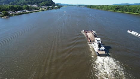 Ein-Schleppboot-Schiebt-Einen-Einzelnen-Lastkahn-Auf-Dem-Mississippi-Nach-Norden,-Vorbei-An-Lansing,-Iowa-1