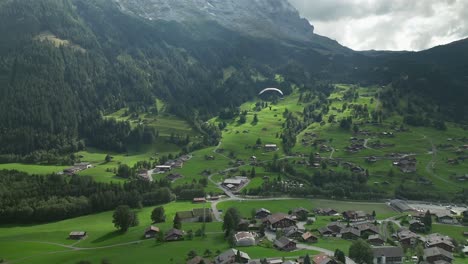 Aerial-view-of-a-paraglider-in-Grindelwald,-Switzerland