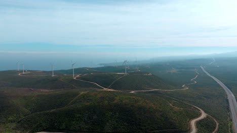 Aerial-orbit-of-wind-turbines-of-a-wind-farm-in-the-uninhabited-mountains-of-northern-Chile,-sunny-day