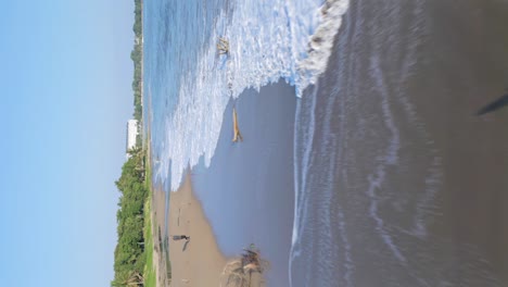 Low-flight-over-sandy-beach-of-Playa-Dorada-in-summer---Dominican-Republic---vertical-shot