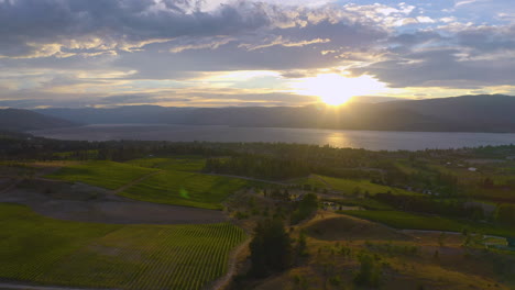 Luftaufnahme-Der-Weingüter-Von-Kelowna,-Wenn-Die-Sonne-über-Den-Bergen-über-Dem-Okanagan-See-Untergeht