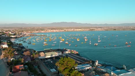 Panoramic-aerial-view-of-the-shore-of-the-Tongoy-peninsula-with-fishing-boats-stopped-at-sunset,-Chile