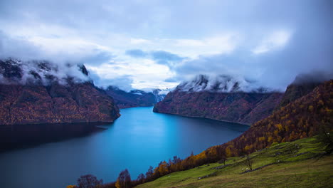 Time-lapse---majestic-fjord-view-from-high-vantage-point,-swirling-mist-around-snow-capped-mountain-peaks,-Flam,-Norway