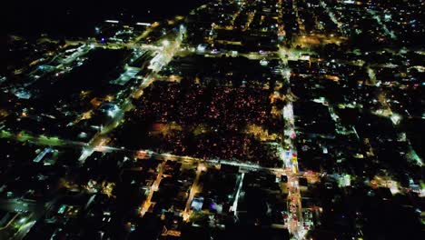 Aerial-view-around-people-visiting-the-dead-at-a-cemetery,-during-Día-de-los-Muertos,-night-in-Mexico-city---orbit,-drone-shot