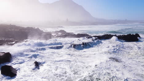 Incessant-waves-pounding-rocky-coastline-with-morning-mist-at-sunrise