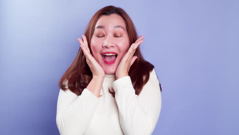 Portrait-of-young-Asian-lady-with-a-positive-expression,-joyful-surprise-funky-and-looking-at-camera-over-violet-background
