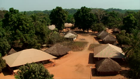 A-village-in-northern-Guinea-Bissau,-with-houses-made-of-straw-and-zinc,-in-the-middle-of-the-forest