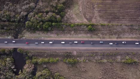 Aerial-view-of-heavy-traffic-on-a-rural-road,-with-cars-of-different-models-and-colors