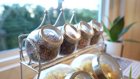 Cute-and-Stylish-Jar-Filled-with-Spice-on-Rack-in-Kitchen,-Close-Up