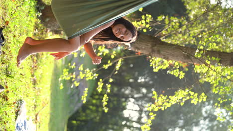 Mujer-De-Pelo-Largo-Y-Negro-Disfrutando-De-La-Vida-En-Su-Hamaca-En-El-Parque-Natural-Durante-Un-Día-Soleado-De-Camping