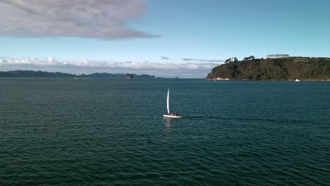 Sailing-yacht-into-the-sunset-of-Mercury-Bay-in-Coromandel,-New-Zealand