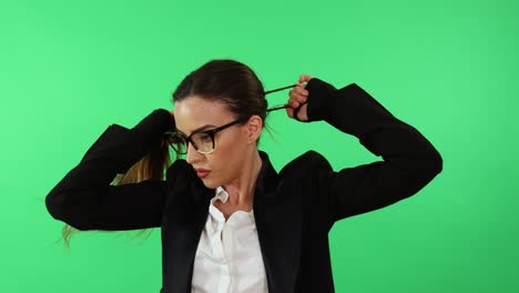 Sexy-businesswoman-with-glasses-and-business-suit-arrange-her-hair-with-ponytail-and-gets-ready-for-work-day-in-office-wearing-punching-gloves