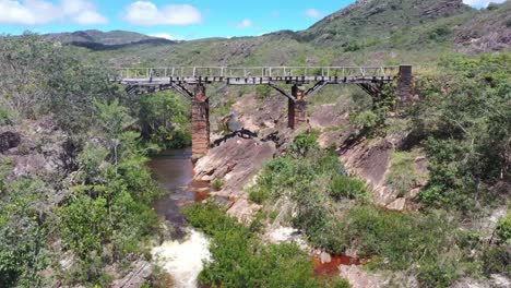 Drone-view-of-an-old-bridge-under-which-river-water-flows