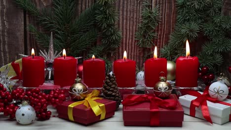 Rote-Weihnachtskerzen-Und-Weihnachtsgif-boxen-Vor-Holzhintergrund