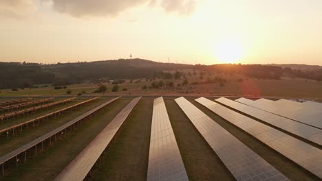 Slow-Aerial-Establishing-Shot-Of-A-Solar-Panel-Field-With-A-Hazy-Sunset-From-The-Wildfire-The-Night-Before-In-Hesse,-Germany
