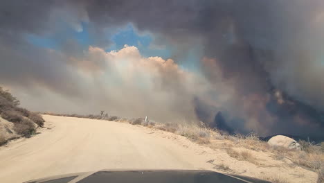 California-Wildfires-2022,-Dark-Smoke-and-Vapors-Above-Land,-Driver's-POV-From-SUV-Vehicle-Moving-on-Dusty-Road