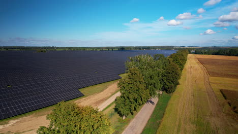 Luftwagen-über-Bäume,-Um-Eine-Riesige-Solarpanel-Farm-Zu-Enthüllen