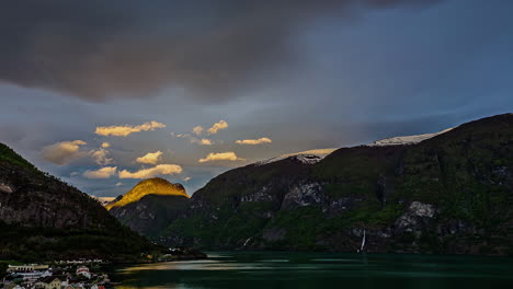 Sunrise-over-the-mountains,-fjord-and-a-lakeside-village-in-Norway---time-lapse