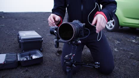 Outdoor-videographer-leveling-camera-on-gimbal,-professional-cameraman-with-equipment