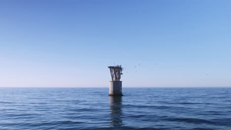 Empty-abandoned-tower-in-the-Mediterranean-Sea-with-seagulls-flying-around-it