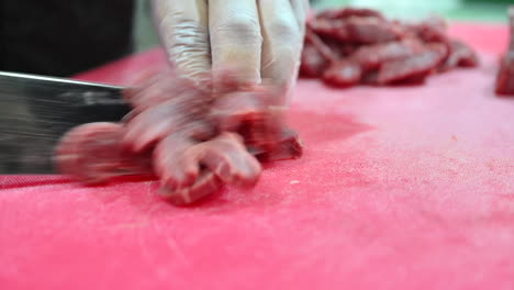 4k:-Chef-cutting-raw-meat-on-a-cutting-board-in-a-professional-kitchen-2