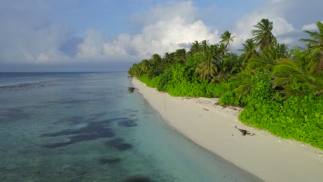 Aerial-dolly-in-over-an-empty-tropical-beach-of-turquoise-water-and-white-sand-of-the-Maldives-at-sunrise