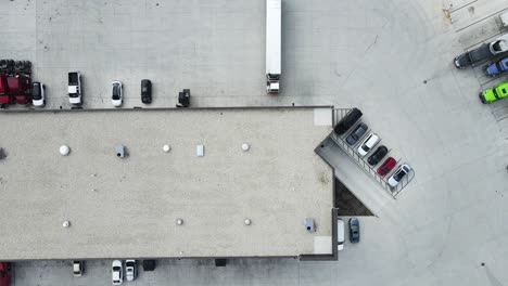 Terminal-tractor-pull-refrigerator-into-bay-repair-shop-aerial-top-down-video-drone-4k