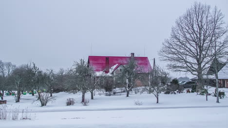 Haus-Mit-Rotem-Dach-Zwischen-Kahlen-Bäumen-In-Verschneiter-Landschaft