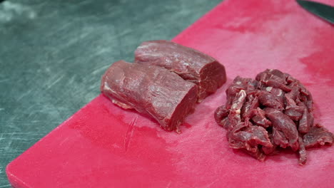 4k:-Raw-whole-and-chopped-Tenderloin-on-a-cutting-board,-Closeup-of-raw-meat-in-slow-motion