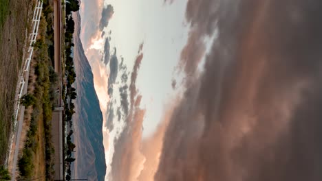 Panoramic-time-lapse-of-stormy-clouds-at-sunset-over-a-mountain-landscape---vertical-orientation