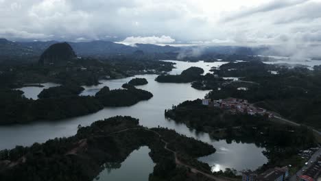 Luftdrohne-Fliegt-über-Guatape-Natürlichen-Berühmten-See-Reisen-Kolumbianische-Inseln-Kristallklare-Wasserlandschaft